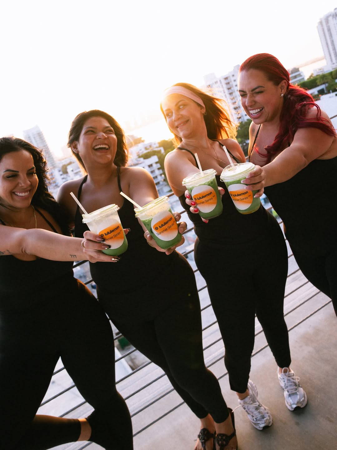 Four friends toasting with Town drinks on a rooftop