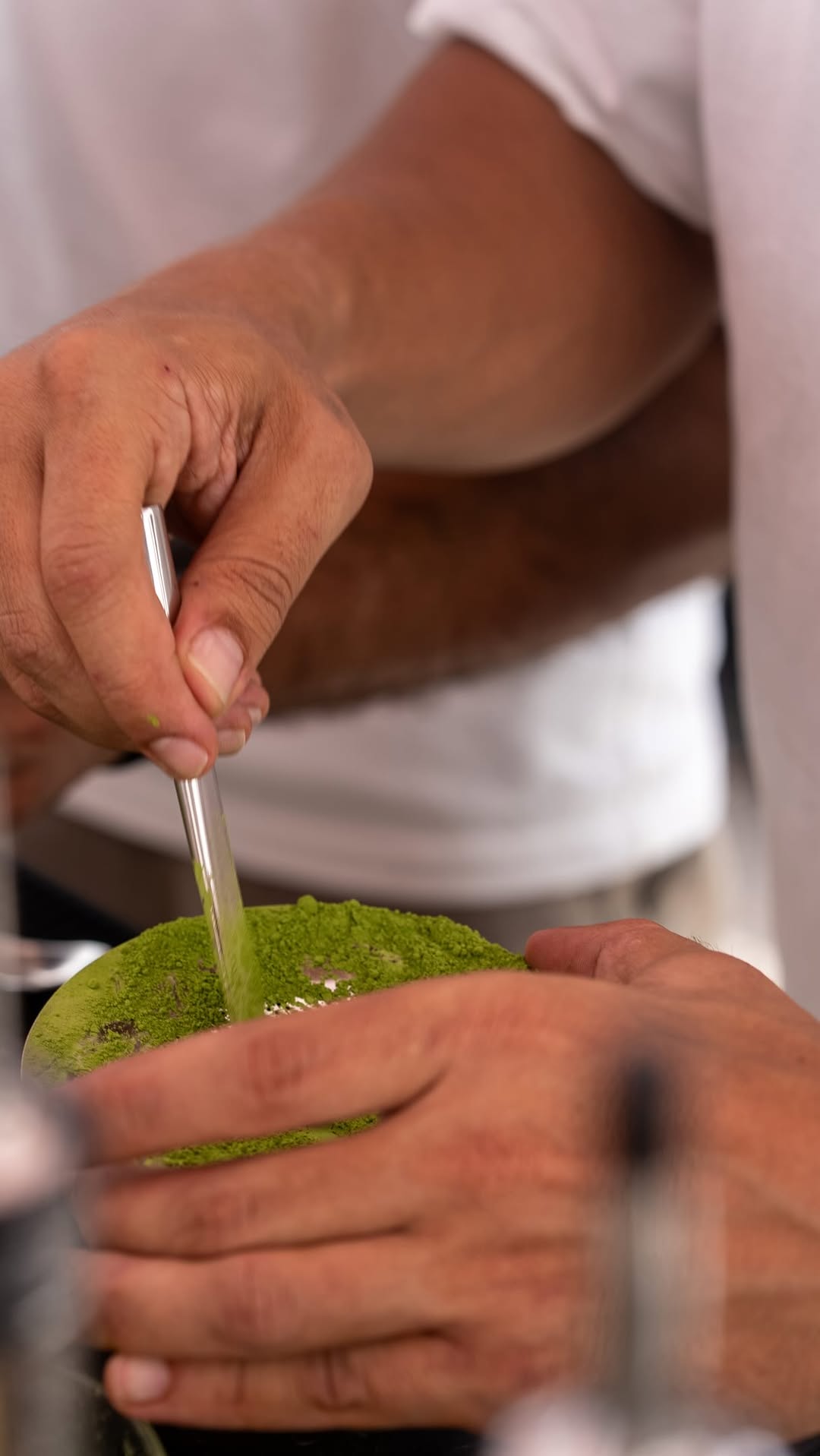 Hands whisking matcha in a bowl