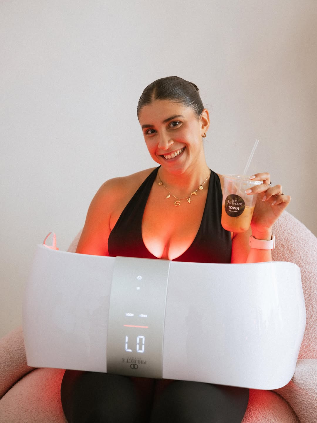 Guest holding a Town iced latte during a wellness session