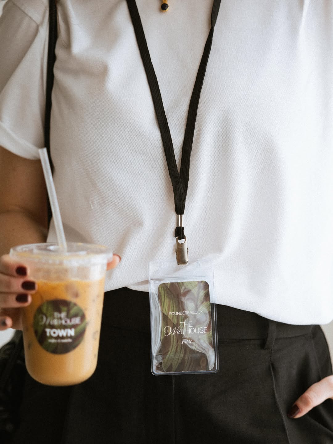 Event attendee with a lanyard holding a Town iced latte